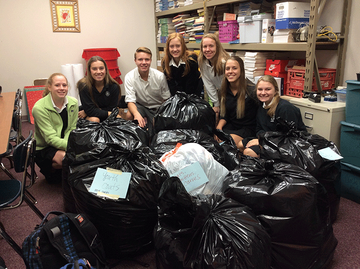 Students gather bags of coats for donation