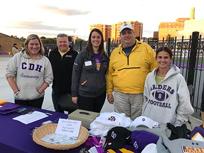 CDH Alumni Association members greet fans as the enter the stadium.